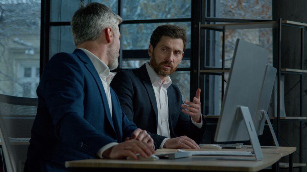 Two,Caucasian,Men,Professional,Businessmen,Work,Together,Using,Computer,In